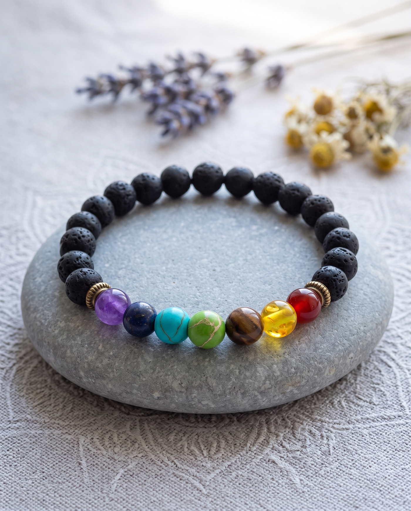 7 chakra bracelet resting on a stone in a calm meditation setting